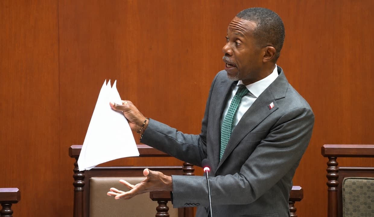 trevor walker in parliament holding document inquisitively