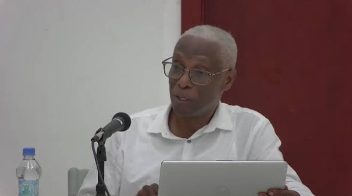 Dr. Daniel speaking at table with mike